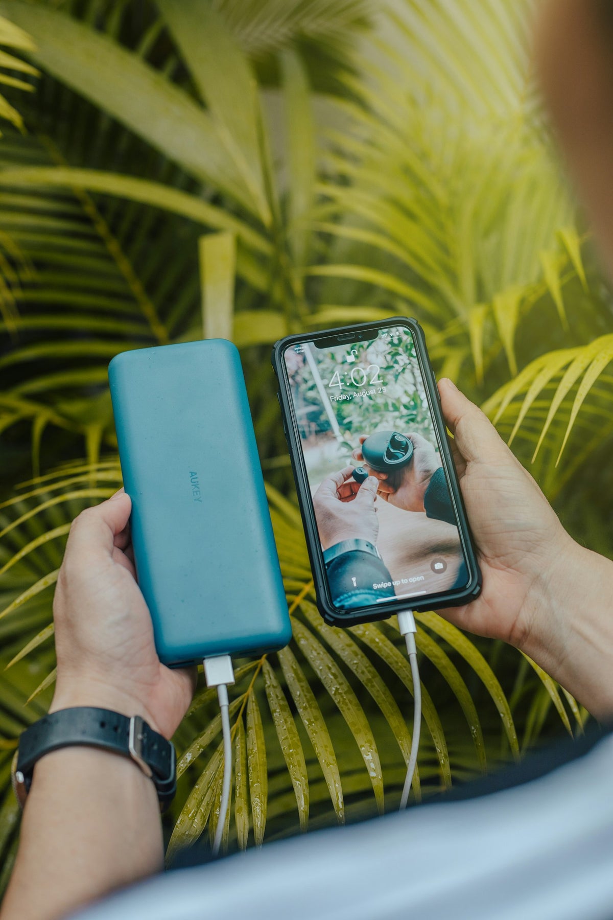 Smartphone wird unterwegs mit einer Powerbank geladen